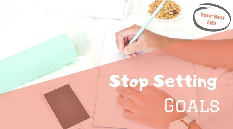 woman's hands writing goals, stop setting goals with these tips